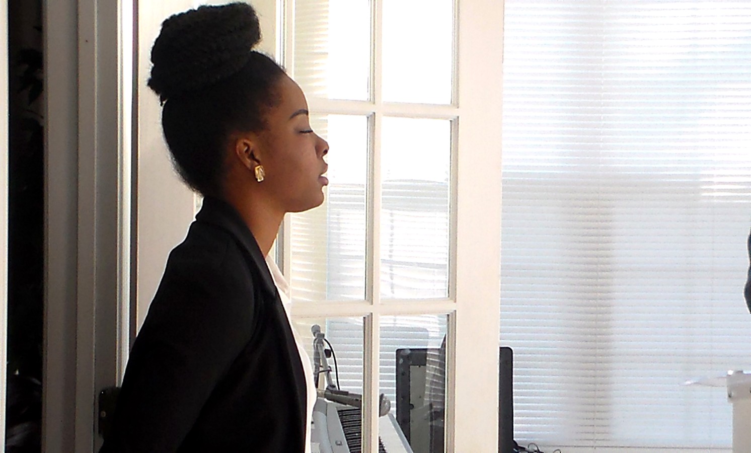A young worshipper in quiet prayer by the window