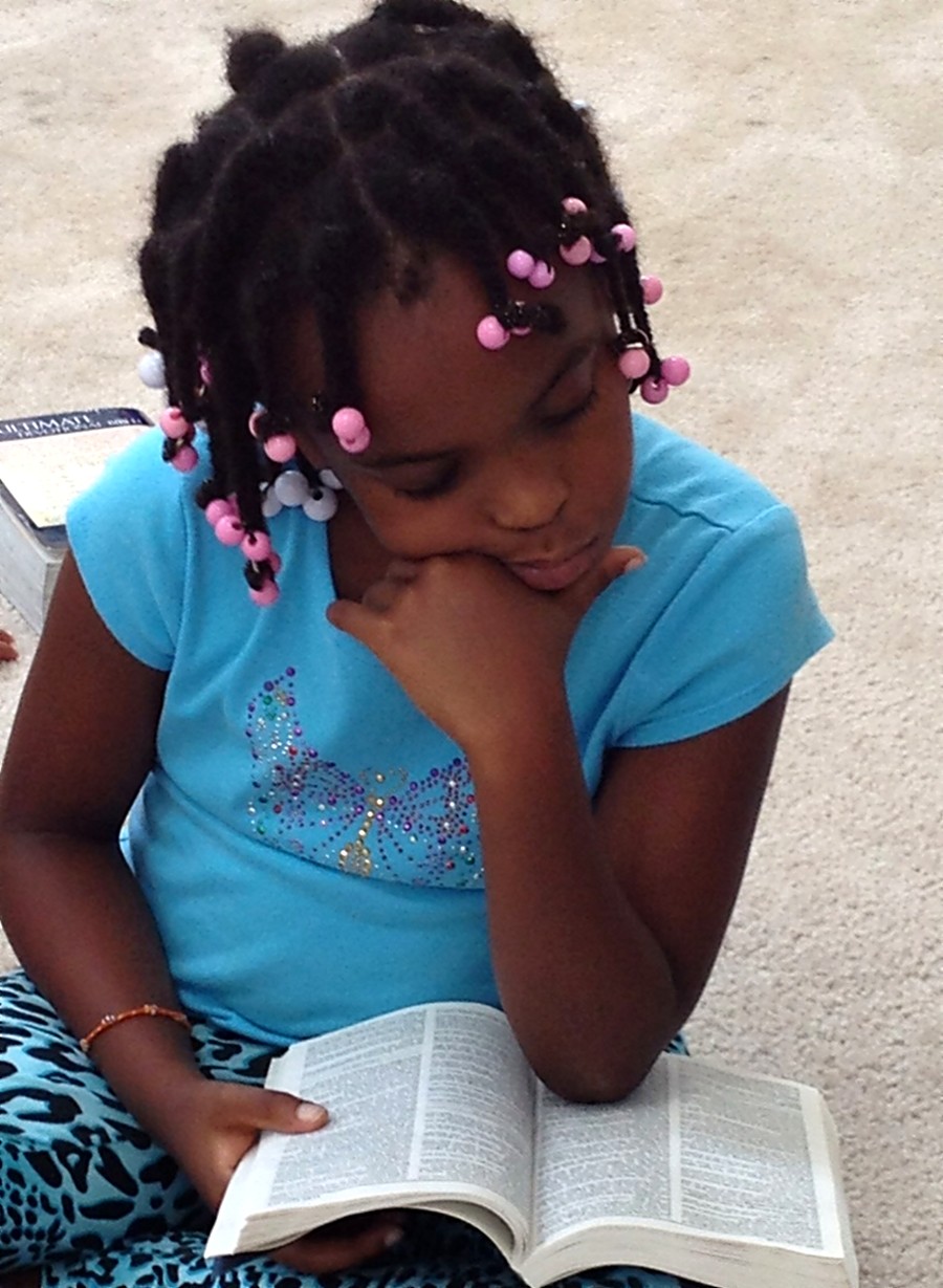 A young girl reading her Bible